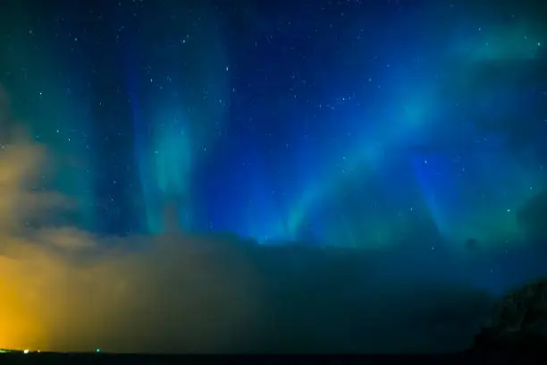 Photo of Aurora Borealis Known as Nother Lights Playing with Vivid Colors Over Lofoten Islands in Norway. Horizontal Image Orientation