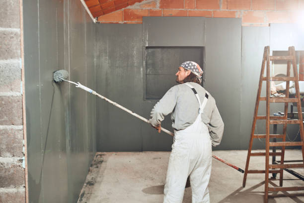 istock Painter painting walls with a extender roller indoors. 1173284989