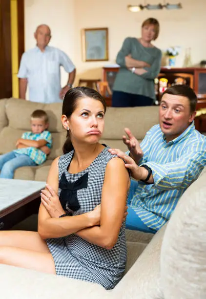 Young frustrated woman having problems in relationship with her large family