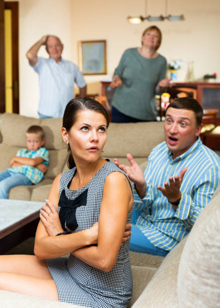 Upset woman after discord with husband and parents Portrait of young woman upset after discord with husband and elderly parents at home father in law stock pictures, royalty-free photos & images