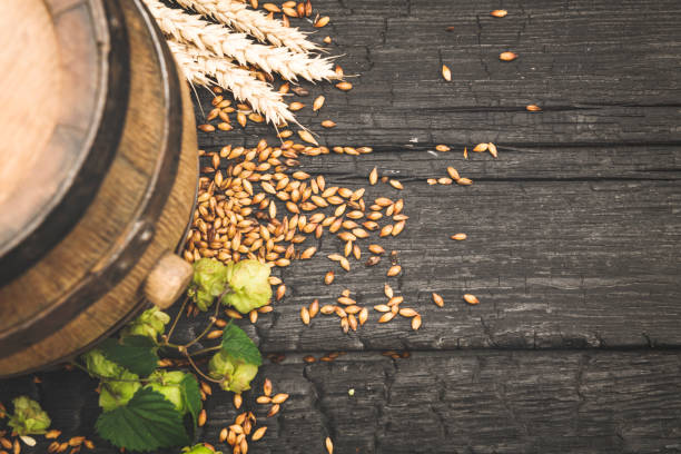 istock Beer surrounded by hops on wooden background 1173285917