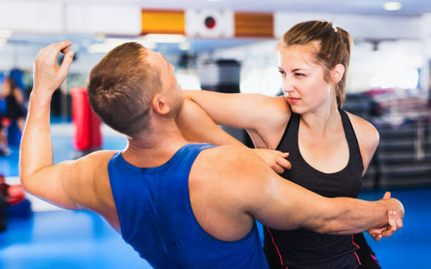 istock Woman is training with man on the self-defense course in gym. 1173286039