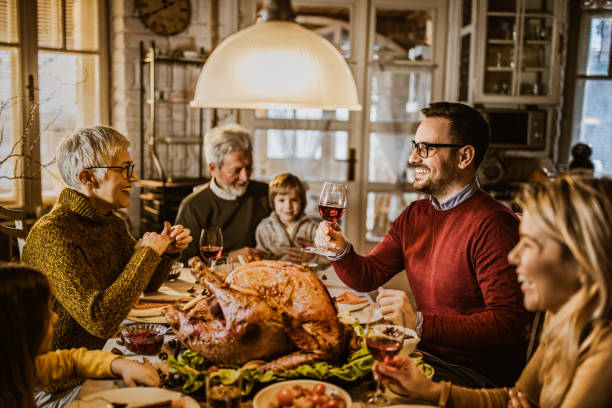 istock Happy extended family talking during Thanksgiving meal at dining table. 1173286243