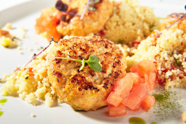 escalopes de viande de dinde avec couscous garnir sur la plaque blanche d'isolement - schnitzel cutlet meat isolated on white photos et images de collection