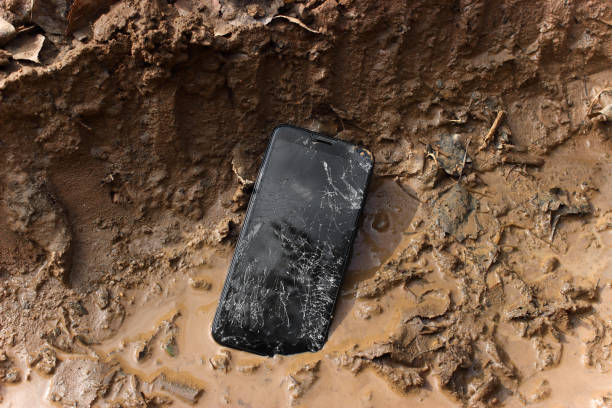 istock Broken smartphone on dirty and wet surfaces. The touch screen is cracked and damaged. 1173290953