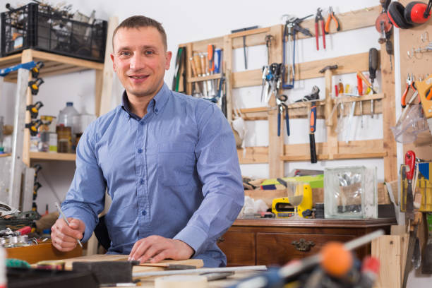 istock young male carpenter working wood plank at workshop 1173292729