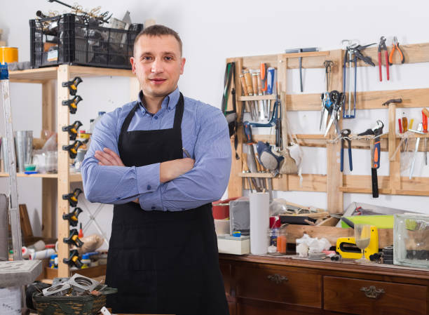 istock Portrait of young handsome carpenter in uniform in workshop. 1173292757