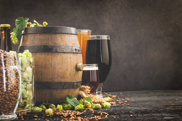 istock Beer surrounded by hops on wooden background 1173293105