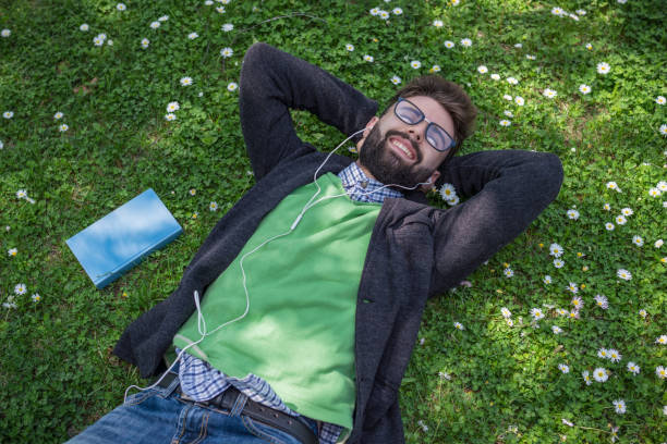 istock Happy young man lying on the grass 1173293192