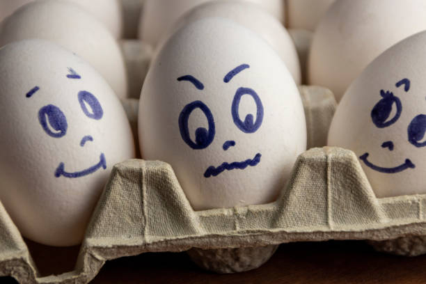 istock Lovely eggs in cardboard box. Eggs with emotions. White eggs in cardboard box with different faces painted on them. Boys and girl. 1173293981