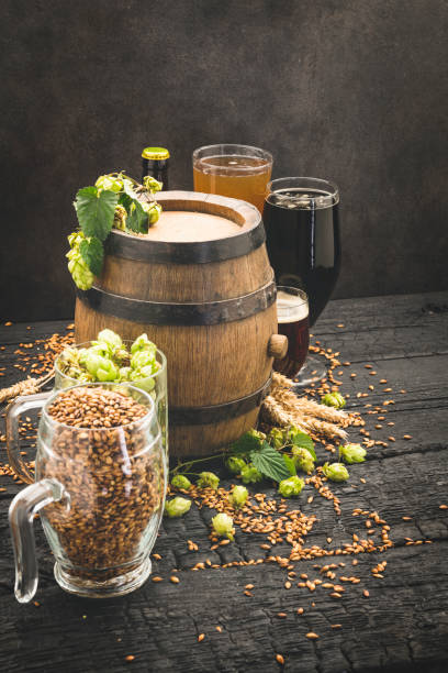 istock Beer surrounded by hops on wooden background 1173294621
