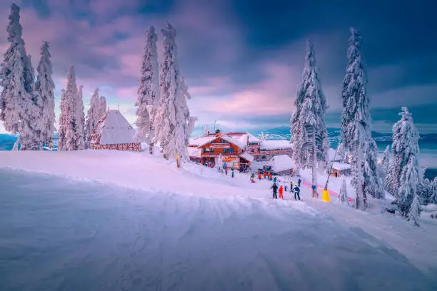 Photo of Famous ski resort with skiers at sunset, Poiana Brasov, Romania