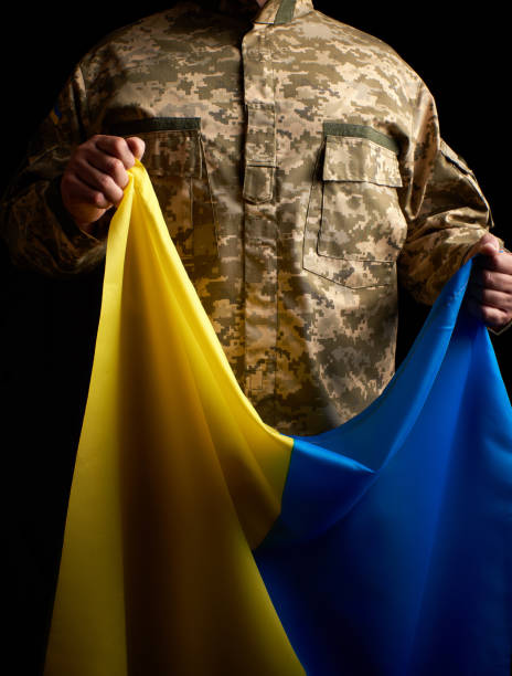 o soldado ucraniano prende em sua mão a bandeira amarelo-azul do estado - pants green camouflage men - fotografias e filmes do acervo