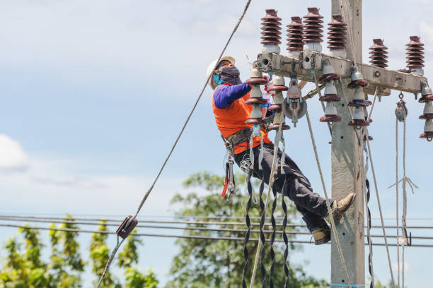istock Low Angle View Of Man Hanging On Telephone Pole Against Sky 1173297636