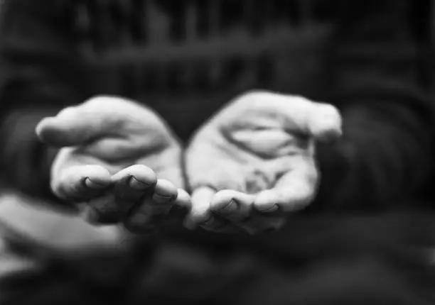 Photo of Hands of a begging homeless man held out in appeal