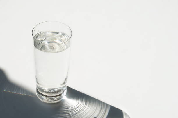 istock glass of water and shadow on a white background. abstract. copy space 1173300379