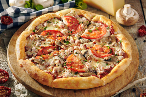 istock Pizza Restaurant Menu - Delicious Fresh Pizza with Mushrooms, Tomatoes and Meat. Pizza on Rustic Wooden Table with Ingredients 1173302844