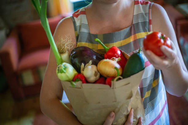 istock Cute redhead holding vegetables in paper bag 1173305687
