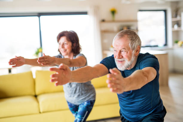 istock A senior couple indoors at home, doing exercise indoors. 1173306413