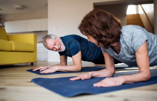 istock A senior couple indoors at home, doing exercise on the floor. 1173306518