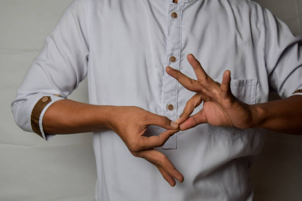 nahaufnahme asiatischen mann zeigt handgesten bedeutet es dolmetscher wertschätzung isoliert auf weißem hintergrund. amerikanische gebärdensprache - hand sign stock-fotos und bilder