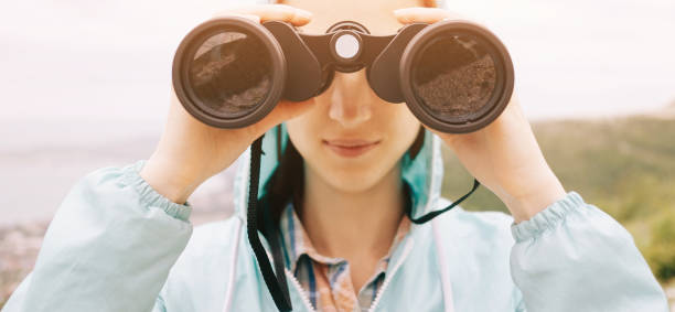 istock Smiling woman watching with binoculars outdoor, front view. 1173309897