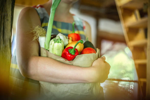 istock Cute redhead holding vegetables in paper bag 1173317090