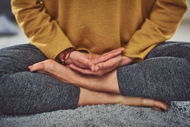 Close up of caucasian woman meditating indoors. Close up of caucasian woman meditating indoors. cross legged stock pictures, royalty-free photos & images
