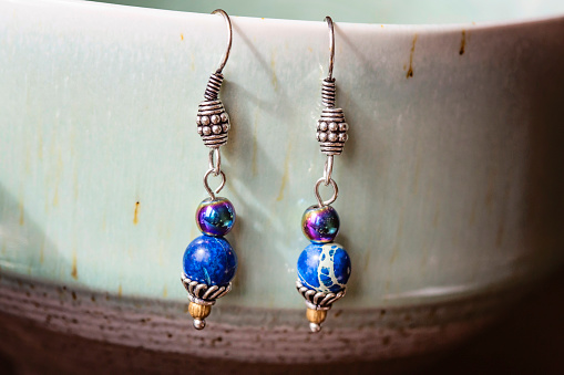 Natural beads earrings hanging on pottery