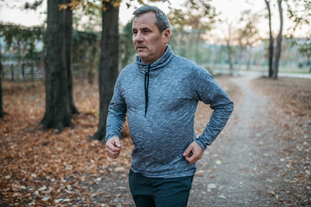 istock An elderly man jogs in a public park 1173323093