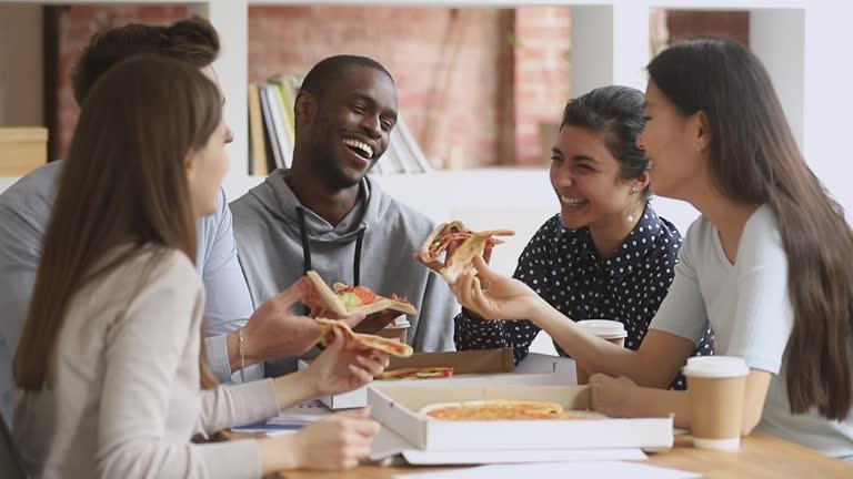 Happy mutiethnic young students people having fun share pizza