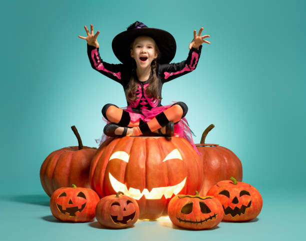 ターコイズの背景に小さな魔女 - child little girls smiling autumn ストックフォトと画像