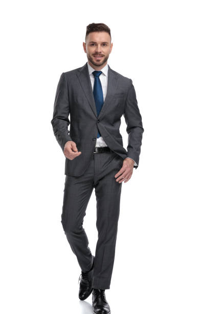 istock relaxed young businessman is walking with one hand in pocket 1173332042