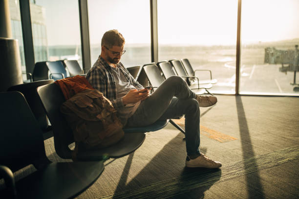 indivíduo que espera no aeroporto - bag boredom bored man casual - fotografias e filmes do acervo