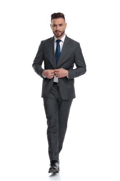istock confident young businessman walking and buttoning his suit 1173332053