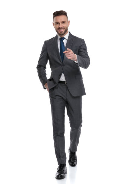 istock relaxed young businessman walks with hand in pocket and points finger 1173332953