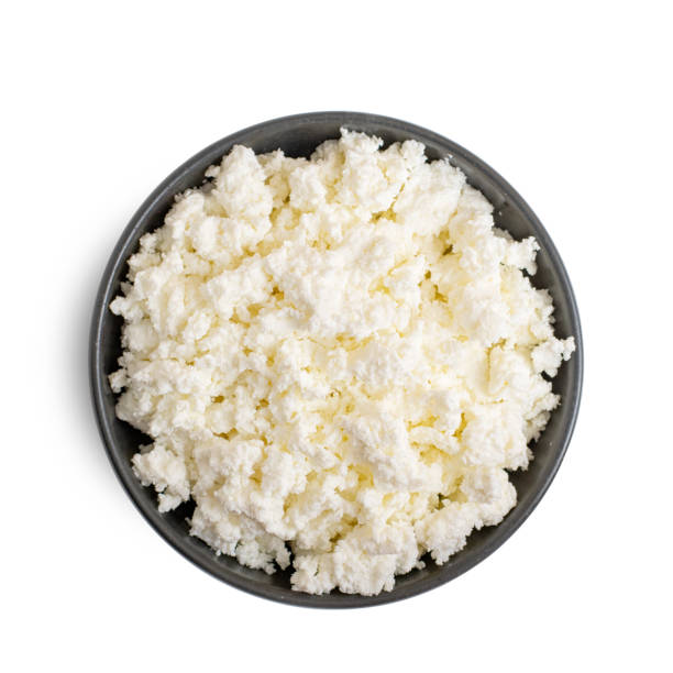 istock Cottage cheese in dark bowl isolated on white background. Top view 1173333887