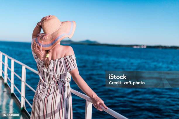 Cruise Ship Vacation Woman Enjoying Travel Vacation At Sea Free Carefree Happy Girl Looking At Ocean And Holding Sunhat Stock Photo - Download Image Now