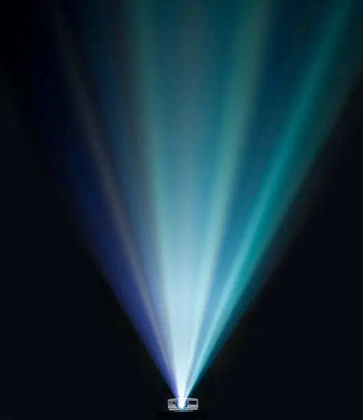 Beams of light from a projector in a dark room.