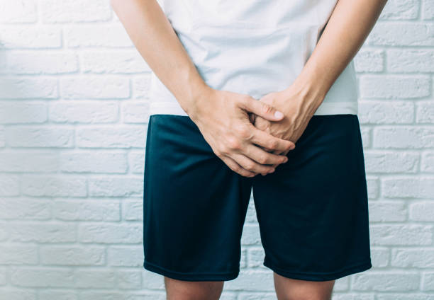 man wearing shorts holding genitals. Men's health, venereologist, sexual disease man wearing shorts holding genitals. Men's health, venereologist, sexual disease erection stock pictures, royalty-free photos & images