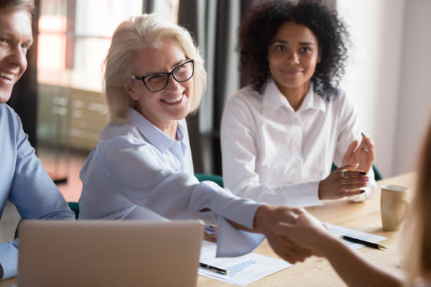 istock Smiling middle-aged employee handshake colleague greeting at briefing 1173335921
