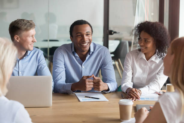 istock Smiling multiracial colleagues negotiate cooperating at meeting 1173335933