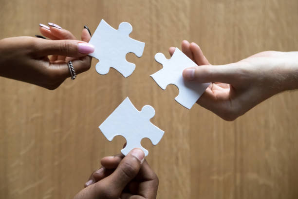 istock Close up of diverse people assemble jigsaw finding best solution 1173335935