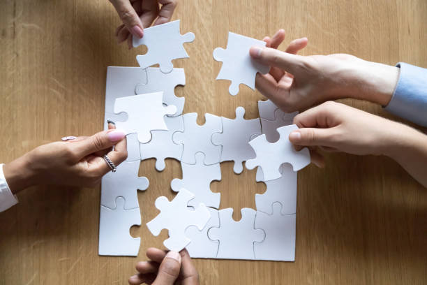 istock Top view of diverse people assemble jigsaw looking for solution 1173335937