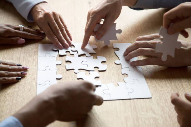 istock Diverse people assemble jigsaw puzzle searching right decision 1173335943