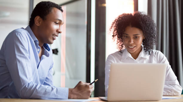 istock African American colleagues cooperating working together at laptop 1173335944