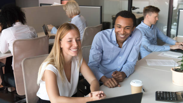 istock Smiling diverse colleagues laugh watching video on laptop in office 1173335976