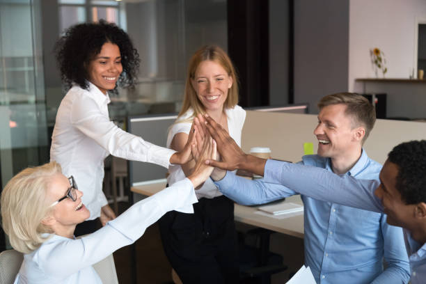 istock Excited diverse colleagues join hands showing unity at meeting 1173335990