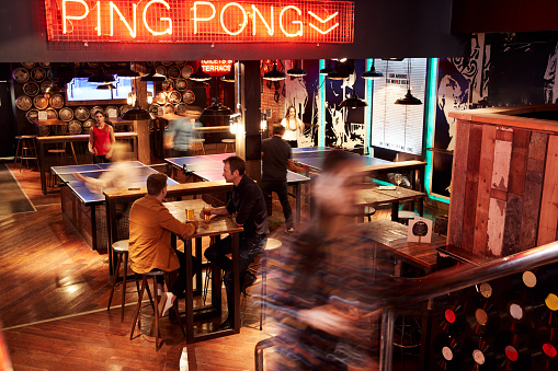 Interior Of Bar With Customers Drinking And Playing Table Tennis