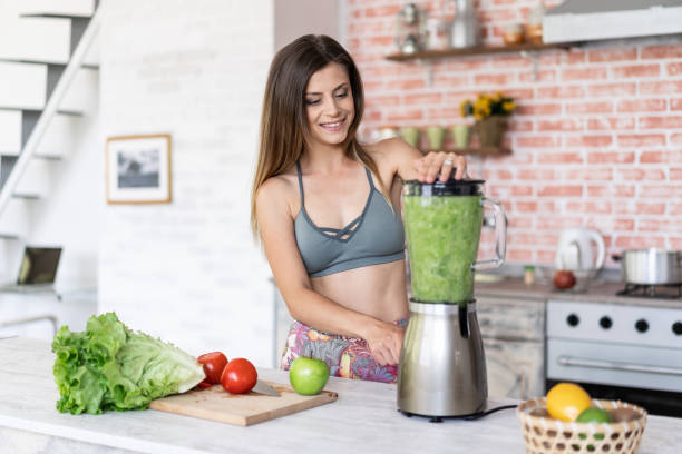 istock Smiling sporty woman making smoothie 1173336919